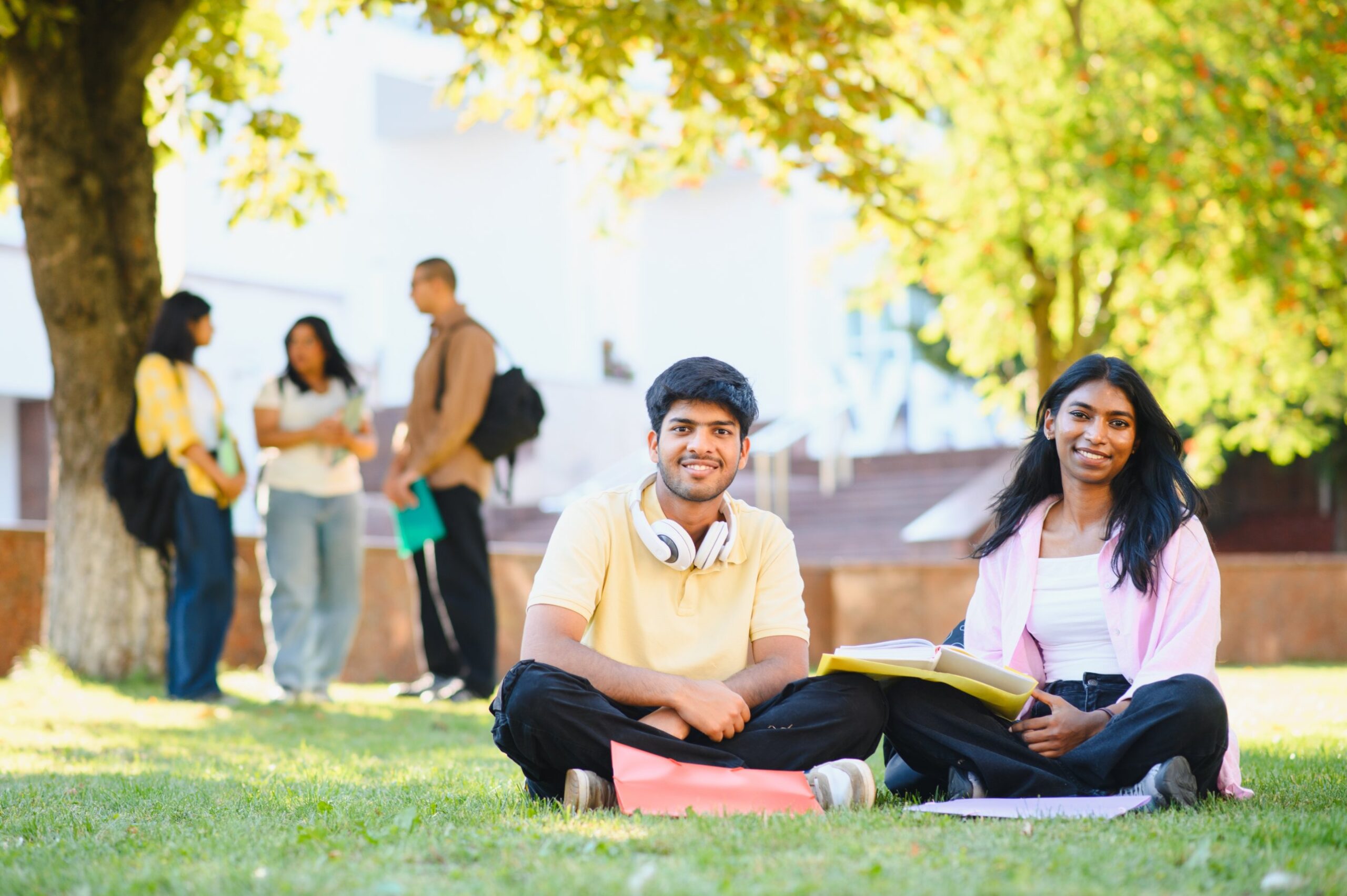 Two students sitting on campus lawn